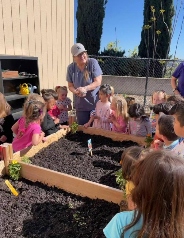 Teacher and students gardening